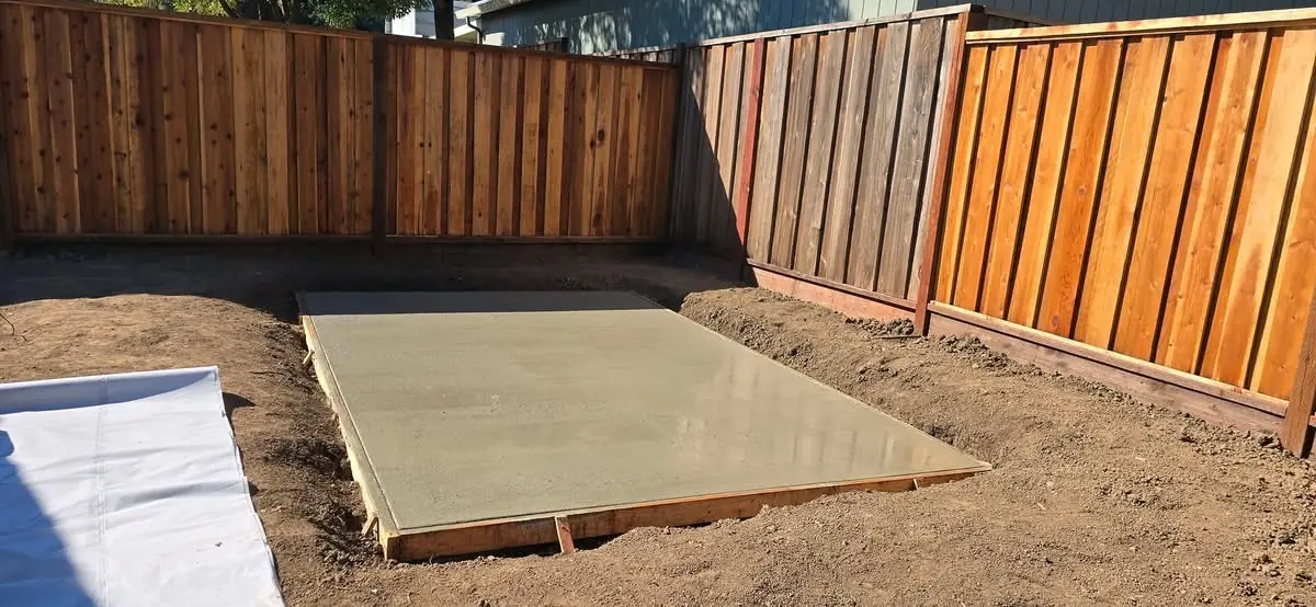 Freshly poured concrete pad ready for the next phase of work